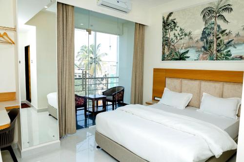a hotel room with a bed and a table at Pearl Inn in Dhārwād
