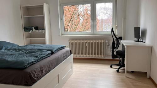 a bedroom with a bed and a desk with a computer at Cute apartment in lovely Constance in Konstanz