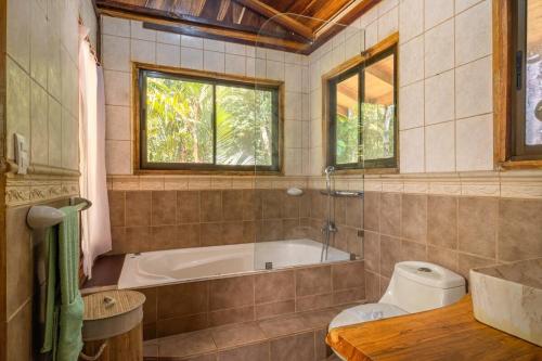 a bathroom with a tub and a toilet at Charming Villa Surrounded by Nature Punta Uva in Puerto Viejo