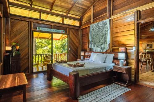 a bedroom with a bed in a room with wooden walls at Charming Villa Surrounded by Nature Punta Uva in Puerto Viejo