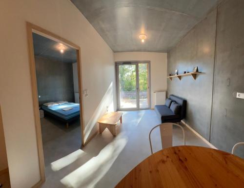 a living room with a table and a room with a bed at Résidences EMA-CNIFOP in Saint-Amand-en-Puisaye