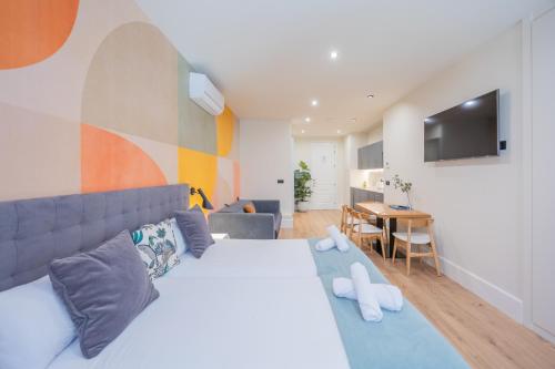 a bedroom with a large bed and a living room at BILBAO RIVERSIDE by STAYNN APARTMENTS in Bilbao