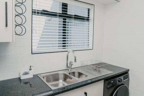 a kitchen with a sink and a window at Gonubie Beachside Delight Apartment in East London