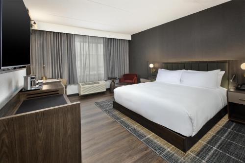 a hotel room with a large bed and a television at DoubleTree by Hilton Hotel Detroit Novi in Novi
