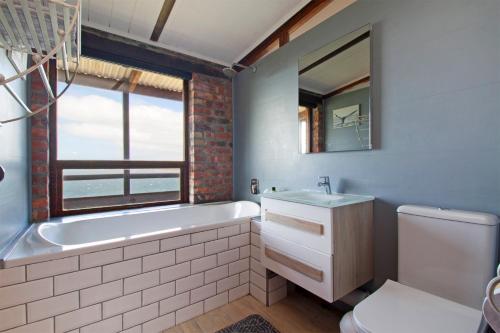 a bathroom with a tub and a sink and a toilet at Hidden Gem in Cape Town