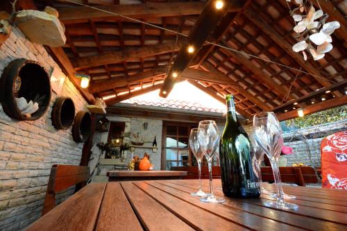 una botella de vino en una mesa de madera con copas de vino en Villa Batur, en Petrčane