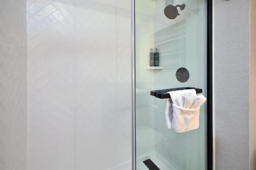 a glass shower door with a towel rack in a bathroom at DoubleTree by Hilton Hotel Detroit Novi in Novi