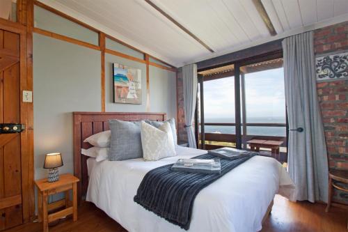 a bedroom with a bed with a view of the ocean at Hidden Gem in Cape Town