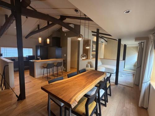 a dining room and kitchen with a wooden table and chairs at 耕 PRIVATE MAISON KOU - Vacation STAY in Kyoto