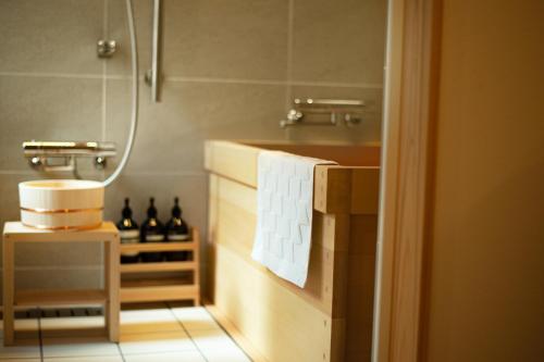 a bathroom with a tub and a sink with a towel at 耕 PRIVATE MAISON KOU - Vacation STAY in Kyoto