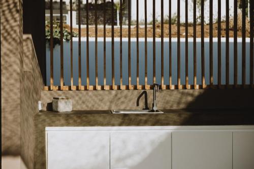 a kitchen counter with a sink and a fence at Villa Morby in Paleros