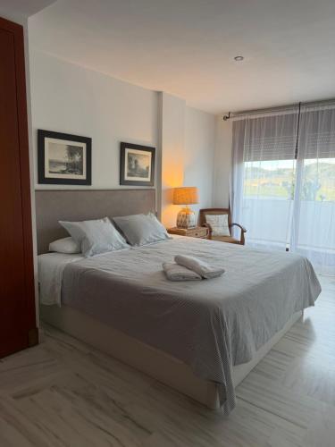 a bedroom with a large bed with two towels on it at Duplex Botánico Resort in Estepona