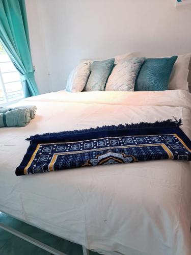 a bed with a blanket and pillows on it at LumaYan, Guesthouse and Cabin in Yan