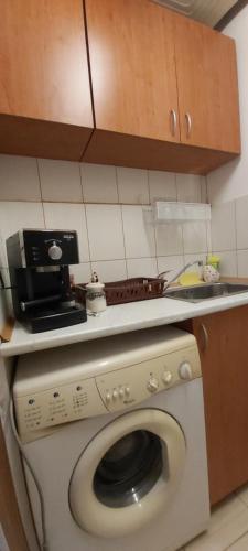 a kitchen with a washing machine and a microwave at Студио in Shumen