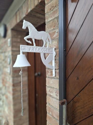 a white horse sign on the side of a door at Papaveri & Papere in Casetta