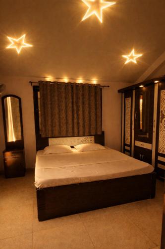 a bedroom with a large bed with stars on the ceiling at Hangout Villa in Malavli