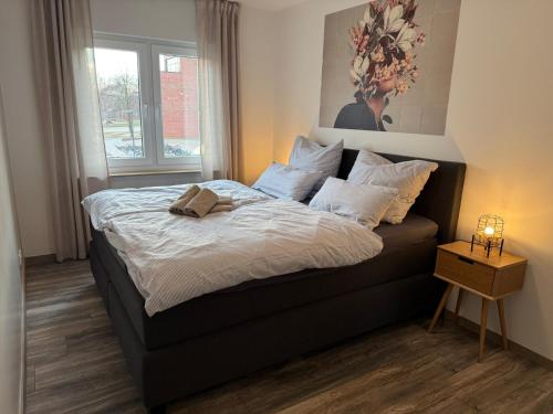 a bedroom with a bed with white sheets and a window at Moderne Wohnung mit Parkplatz und Kaffeevollautomat in Zülpich