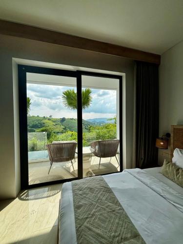 a bedroom with a bed and a view of a patio at Truntum Boutique Mandalika in Kuta Lombok