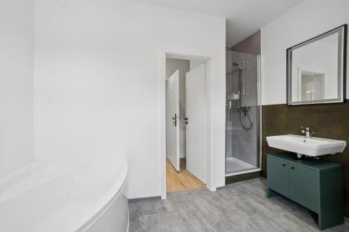 a bathroom with a sink and a shower and a mirror at Apartment Alte Bäckerei in Zwenkau
