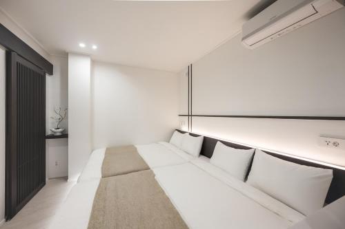 a bedroom with a large white bed with white pillows at GOYURe 고유리 in Seoul