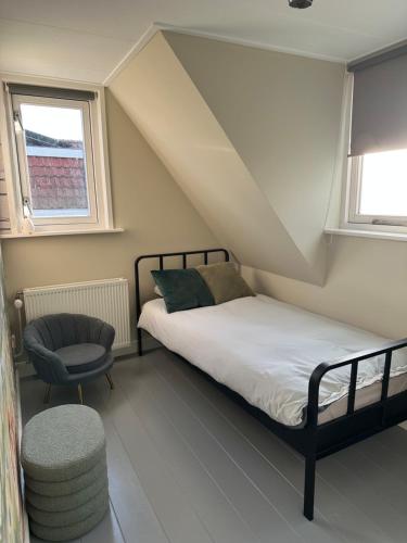 a small bedroom with a bed and a chair at Beautiful entire house in the center in Medemblik