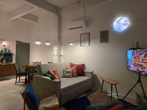 a living room with a couch and a tv at Dramatic Exit Bangkok - Cozy Loft House near Suvarnabhumi Airport in Bangkok
