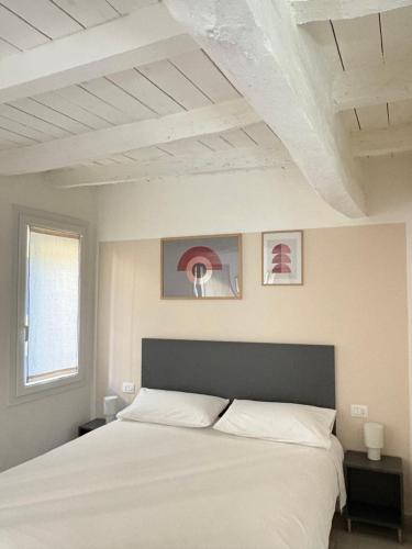 a bedroom with a large white bed and a window at Terrazza Montegrappa in Reggio Emilia