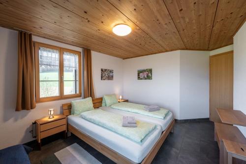 a bedroom with a bed and a wooden ceiling at Bed and Breakfast Bauernhof Bättwil in Burgdorf