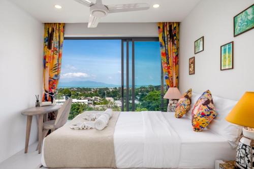 a bedroom with a bed and a large window at Stunning X Space Villa Sea View Infinity Pool in Koh Samui