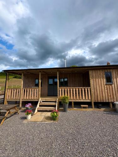 a building with a porch and flowers in front of it at Dark Skies den in Fryup