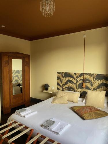 a bedroom with a large white bed with a mirror at La Bouchère 33 in Meuzac