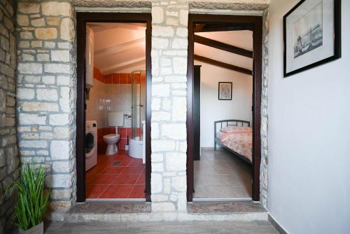 a hallway leading to a bedroom with a bed and a bathroom at Zminj Apartments in Žminj
