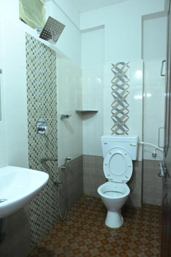 a bathroom with a toilet and a sink at Hotel Jaganmatha Kollur in Kollūru
