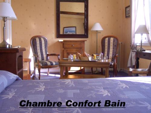 a bedroom with a bed and a table and chairs at Hostellerie de la Bouriane in Gourdon-en-quercy