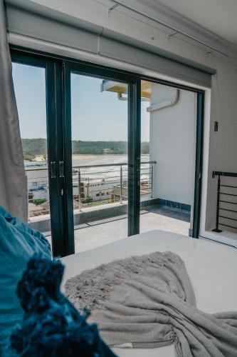 a bedroom with a large window with a view of the ocean at Gonubie Beachside Delight Apartment in East London