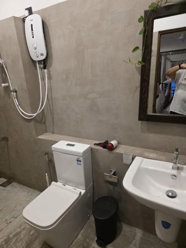 a bathroom with a toilet and a sink at Oshans Home - Guest House - Polhena in Matara