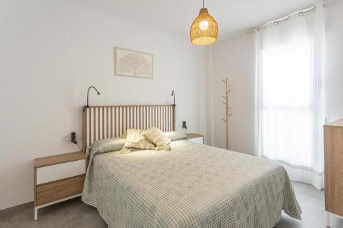 a bedroom with a bed with a blanket and a lamp at AT Ponent VI in Oliva
