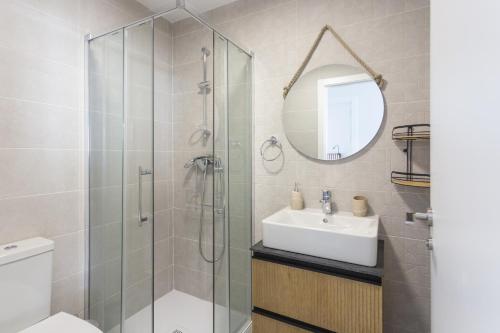 a bathroom with a shower and a sink and a mirror at AT Ponent VI in Oliva