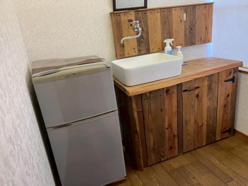 a kitchen with a sink and a refrigerator at みんなの家ポレポレ in Urugi
