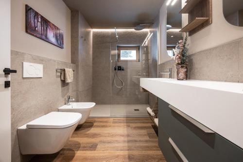 a bathroom with a white toilet and a sink at Chalet Strui in Danta