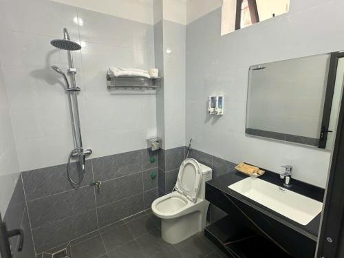 a bathroom with a toilet and a sink and a shower at Trần Hưng Đạo 186 in Na Ngô