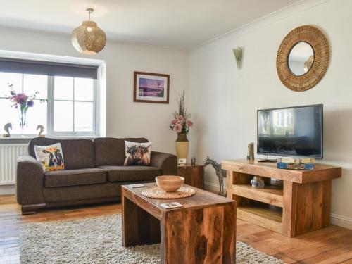 a living room with a couch and a tv at The Barn in New Herrington