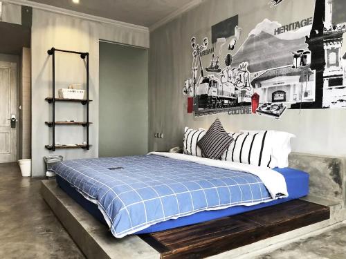 a bedroom with a large bed with a blue blanket at d'primahotel Yogyakarta in Yogyakarta