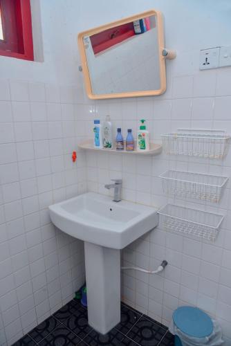 a bathroom with a sink and a mirror and a toilet at Niko Villa in Kosgoda