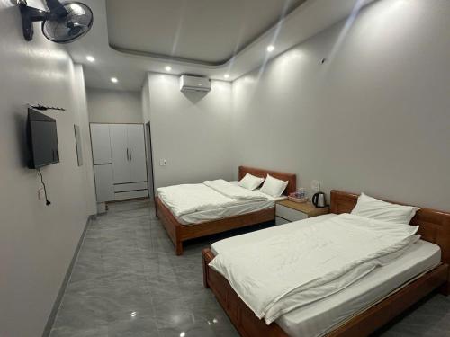 a room with two beds and a flat screen tv at Trần Hưng Đạo 186 in Na Ngô