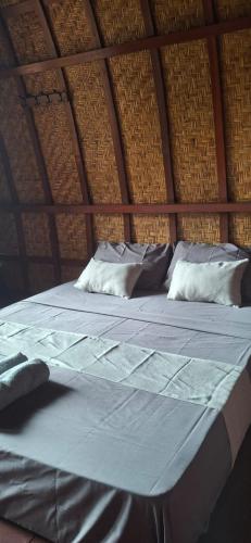 a large bed with white sheets and pillows at Five Time homestay Syariah in Selaparang