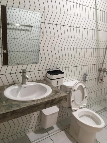 a bathroom with a toilet and a sink at Malee Guesthouse in Ban Rak Thai