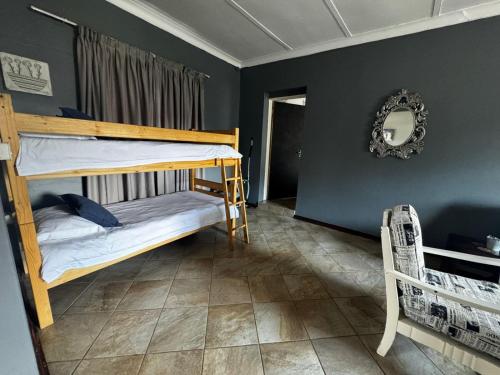 a bedroom with two bunk beds and a mirror at Kort a Moi in Lichtenburg