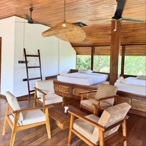a bedroom with two beds and a table and chairs at Tribe Wilpattu - Eco Lodge in Wilpattu