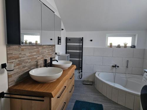 a bathroom with two sinks and a bath tub and a tubermott at Ferienhof Mittermair in Vorderstoder